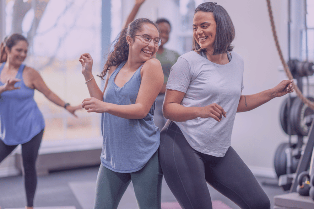 Mujeres moviéndose a ritmo de zumba en un interior.